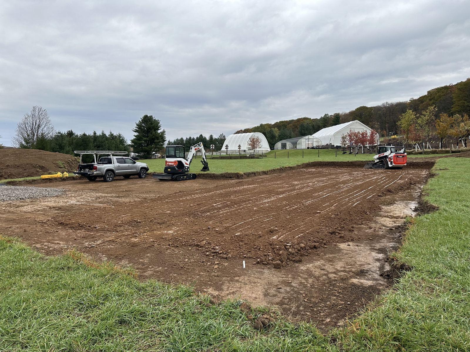 Trucks and equipment staged on the graded pad at Green Meadow.