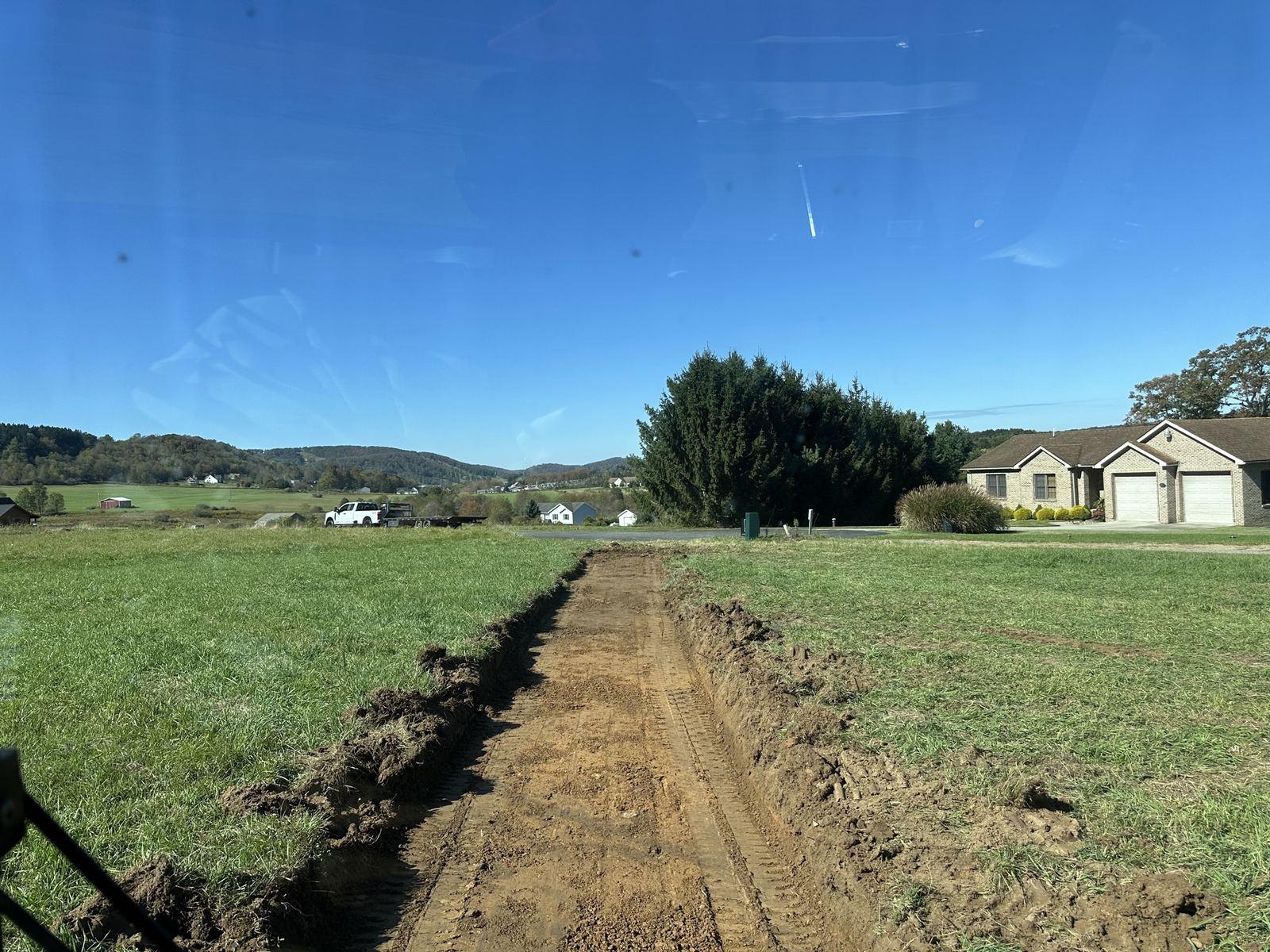 A trench line across the field toward the house at Green Meadow.