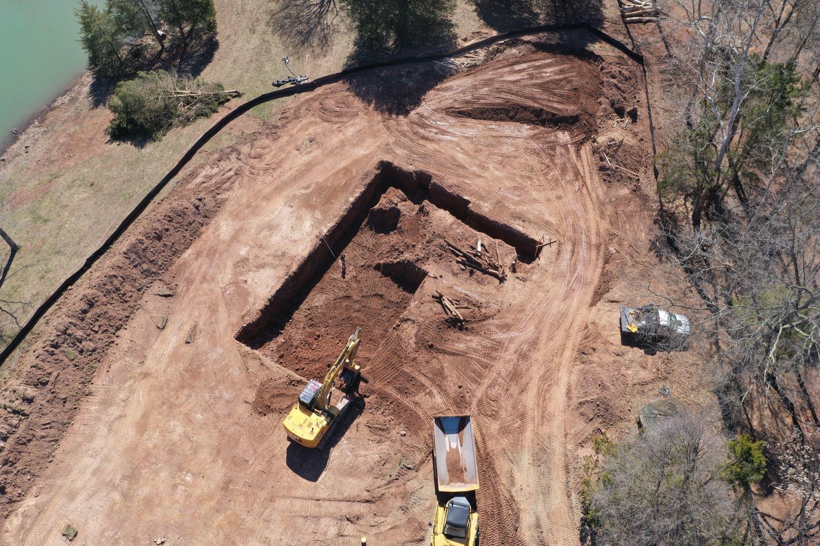 A basement excavation at Haymarket, with an excavator and a dump truck on the pad.