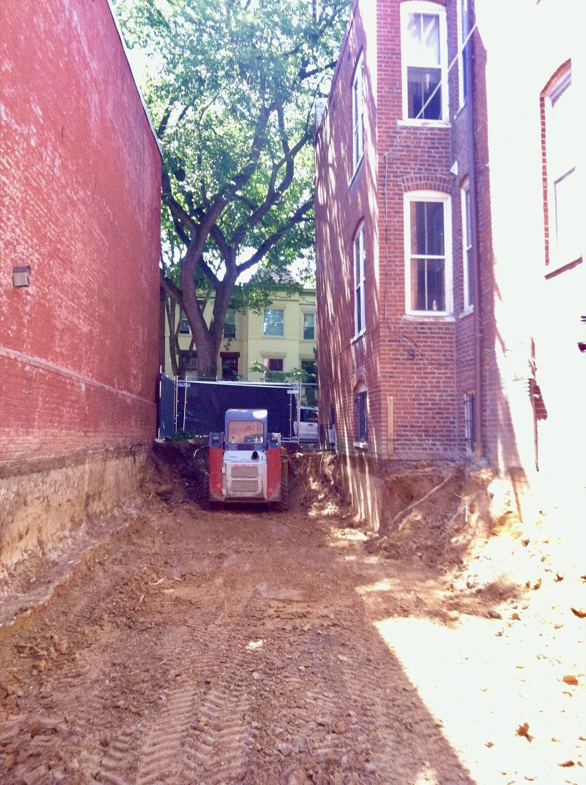 A Bobcat T66 working a tight alley between rowhouses at the Ontario project.