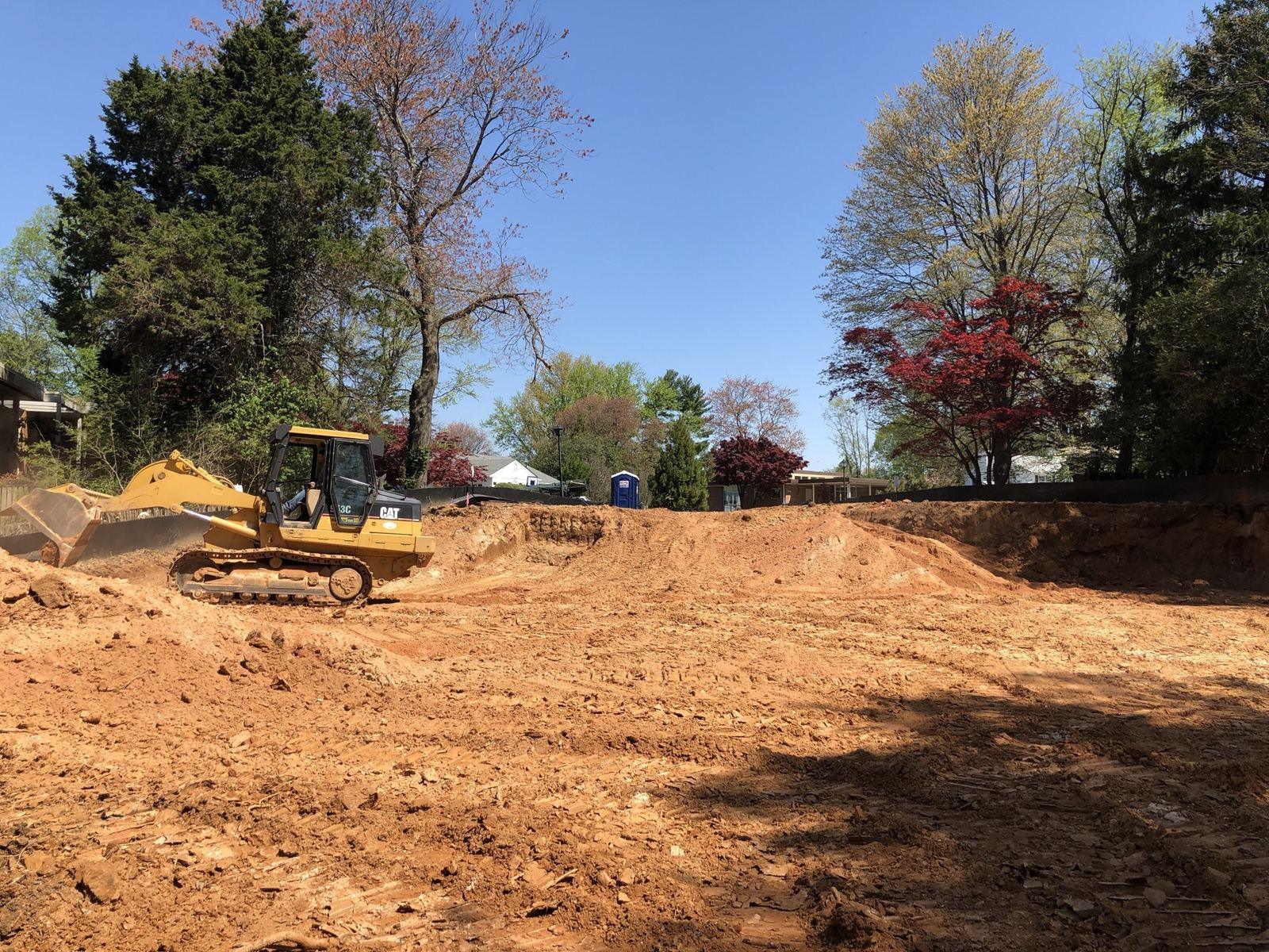 A dozer grading at Touchstone, with the house behind it.