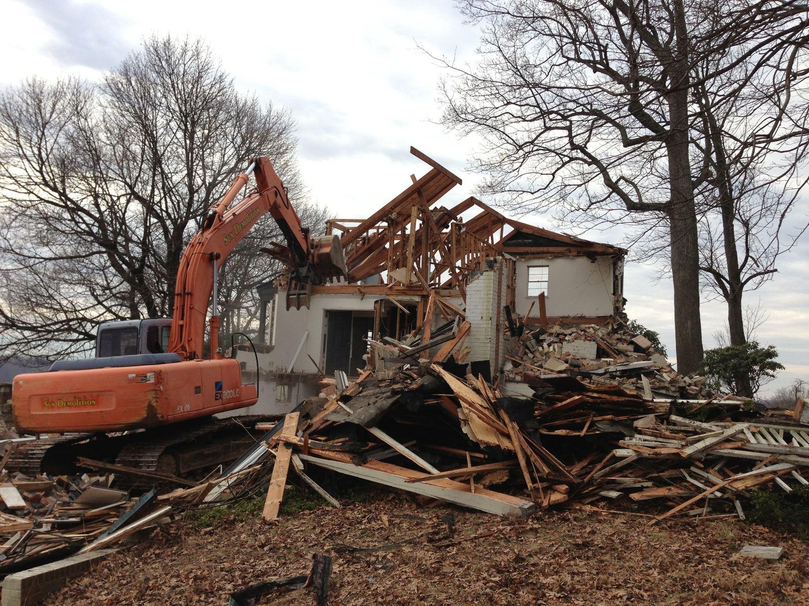 An excavator taking down a farmhouse at the Wildcat project.